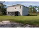 Home exterior showcasing a large backyard and screened patio at 3681 Magnolia Dr, Indian Lake Estates, FL 33855