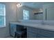 Double vanity bathroom with gray cabinets, a large mirror, and a shower at 3681 Magnolia Dr, Indian Lake Estates, FL 33855