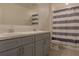 Bathroom with double vanity, shower/tub combo, and striped shower curtain at 3681 Magnolia Dr, Indian Lake Estates, FL 33855