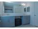 Double vanity bathroom with gray cabinets and large mirror at 3681 Magnolia Dr, Indian Lake Estates, FL 33855