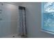Clean shower with tile surround and patterned shower curtain at 3681 Magnolia Dr, Indian Lake Estates, FL 33855