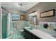 Retro bathroom with teal tile, tub, and vanity at 1614 King James Ct, Lakeland, FL 33813
