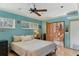Spacious bedroom with light blue walls, ceiling fan, and access to the hallway at 1614 King James Ct, Lakeland, FL 33813