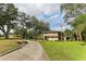 House with a long driveway and mature trees on the property at 1614 King James Ct, Lakeland, FL 33813