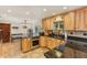 Kitchen features island, light wood cabinets, granite countertops, and stainless steel appliances at 1614 King James Ct, Lakeland, FL 33813