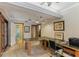 Home office with L-shaped desk, tile floor, and access to sunroom and pool at 1614 King James Ct, Lakeland, FL 33813