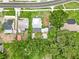 This bird's eye view shows a property with mature trees and a detached garage in a residential area at 415 Avenue K Ne, Winter Haven, FL 33881