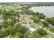 Aerial view of home showcasing neighborhood, nearby lake, and mature trees at 415 Avenue K Ne, Winter Haven, FL 33881