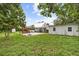 A spacious backyard features a manicured lawn, shade trees, privacy fence, and a storage shed at 415 Avenue K Ne, Winter Haven, FL 33881