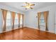 Bright bedroom boasts three windows adorned with drapes and gleaming hardwood floors at 415 Avenue K Ne, Winter Haven, FL 33881
