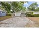 Exterior shot of the house with garage, driveway, and partial fence in the front at 415 Avenue K Ne, Winter Haven, FL 33881
