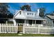 Quaint cottage exterior featuring a metal roof and white picket fence at 415 Avenue K Ne, Winter Haven, FL 33881