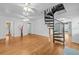 Spacious living room with a unique spiral staircase and beautiful hardwood flooring at 415 Avenue K Ne, Winter Haven, FL 33881
