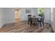 Dining area with table and four chairs, hardwood floors, and view into kitchen at 521 W Voorhis Ave, Deland, FL 32720