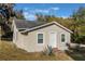 Newly renovated house exterior, featuring a light beige stucco finish and a well-maintained lawn at 521 W Voorhis Ave, Deland, FL 32720