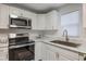 Modern kitchen with stainless steel appliances and white cabinets at 521 W Voorhis Ave, Deland, FL 32720