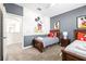Bright bedroom with two twin beds, a Mickey Mouse mural, and access to a hallway at 601 Drop Shot Dr, Davenport, FL 33896