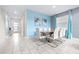 Dining area with a wood table, white chairs, and blue accent wall at 601 Drop Shot Dr, Davenport, FL 33896