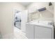 Bright laundry room with washer, dryer, and overhead shelving at 601 Drop Shot Dr, Davenport, FL 33896