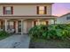 Tan two-story condo building with red-trimmed windows and lush landscaping at 980 Canal View Blvd # G1, Port Orange, FL 32129