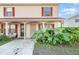 Tan two-story condo with red-trimmed windows and lush landscaping at 980 Canal View Blvd # G1, Port Orange, FL 32129