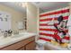 Bathroom with single vanity, Mickey Mouse themed decor, and shower/tub combo at 1463 Myrtlewood St, Davenport, FL 33896