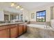 Bathroom with double vanity, soaking tub, and large window at 1463 Myrtlewood St, Davenport, FL 33896