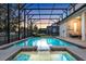 Screened-in pool and spa with a view of the surrounding landscape at 2541 Shanti Dr, Kissimmee, FL 34746