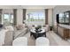 Spacious living room with lake view, comfy seating, and large windows at 289 Woodsage Pl, Lake Alfred, FL 33850