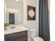 Modern bathroom with dark brown vanity and a white toilet and sink at 264 Woodsage Pl, Lake Alfred, FL 33850