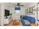 Versatile bonus room with a comfy blue couch and a large TV at 264 Woodsage Pl, Lake Alfred, FL 33850