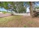 Large backyard with mature trees and a small patio at 5880 Driftwood Dr, Winter Haven, FL 33884