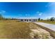 Charming single-story home featuring a durable metal roof, a concrete driveway, and a spacious front yard at 6085 Lightsey Rd, Fort Meade, FL 33841