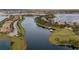 An aerial view of a waterfront community with a serene lake, lush landscaping, and charming homes with private boat docks at 7833 Freestyle Ln, Winter Garden, FL 34787