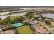 Aerial view of a lake community with large homes, swimming pools, and a tennis court at 7833 Freestyle Ln, Winter Garden, FL 34787
