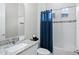Bathroom with a granite countertop vanity, white subway tiles and an enclosed tub with blue curtain at 7833 Freestyle Ln, Winter Garden, FL 34787