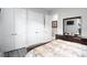 Well-lit bedroom with gray flooring, white doors, and a modern dark wood dresser with a large mirror at 7833 Freestyle Ln, Winter Garden, FL 34787