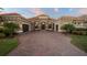Stunning front of home with brick driveway, three-car garage and manicured landscaping at 7833 Freestyle Ln, Winter Garden, FL 34787