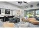 Bright living room featuring curved couches, a glass coffee table, that flows into a modern kitchen with bar seating at 7833 Freestyle Ln, Winter Garden, FL 34787