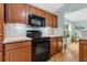 Well-equipped kitchen featuring black appliances and wood cabinets at 1011 Susan Dr, Lake Wales, FL 33853