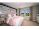 Bright bedroom with leafy accent wall, plush bedding, and large windows at 1596 Ellesmere Ave, Haines City, FL 33844