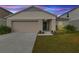 Tan house with a two-car garage and landscaped lawn at 1536 Axel Cir, Winter Haven, FL 33880