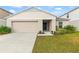 Tan house with a two-car garage and landscaped lawn at 1536 Axel Cir, Winter Haven, FL 33880