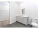 Bathroom features gray wood-look flooring, a white vanity with mirror, and an adjacent walk-in closet with wire shelving at 308 Bass Ct, Poinciana, FL 34759