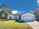 Charming single-story home featuring a well-manicured lawn, attached two-car garage and crisp white paint at 308 Bass Ct, Poinciana, FL 34759