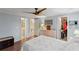 Spacious bedroom with ceiling fan, wood floors, and access to bathroom at 1724 Magnolia Ave, Lady Lake, FL 32159
