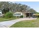 Single-story home with carport, golf cart, and mature landscaping at 1724 Magnolia Ave, Lady Lake, FL 32159