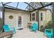 Outdoor screened patio with teal chairs and a small table at 1724 Magnolia Ave, Lady Lake, FL 32159