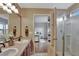 Double vanity bathroom with a view into the bedroom and a walk-in shower at 8710 Hinsdale Heights Dr, Polk City, FL 33868