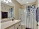 Clean bathroom with shower/tub combo, vanity, and leafy shower curtain at 8710 Hinsdale Heights Dr, Polk City, FL 33868